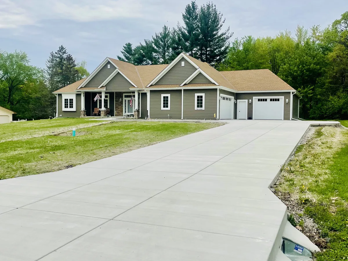 Newly poured concrete driveway leading to the attached garage of a recently built home