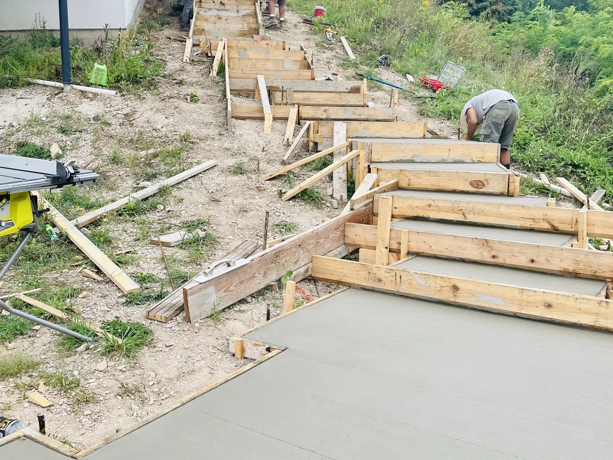 Wooden forms built into a sloped yard in preparation for pouring a run of concrete steps