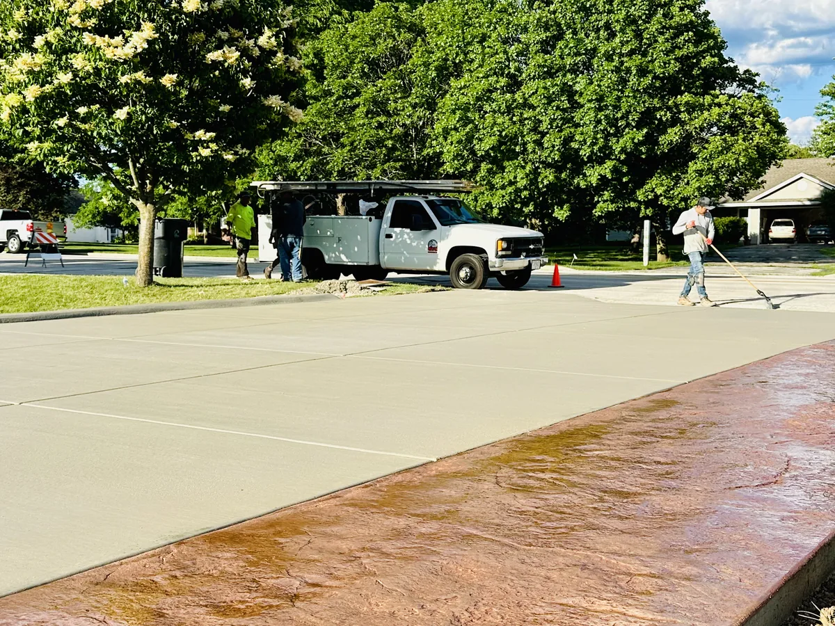 Concrete driveway finished with a wide terracotta stamped border along one edge